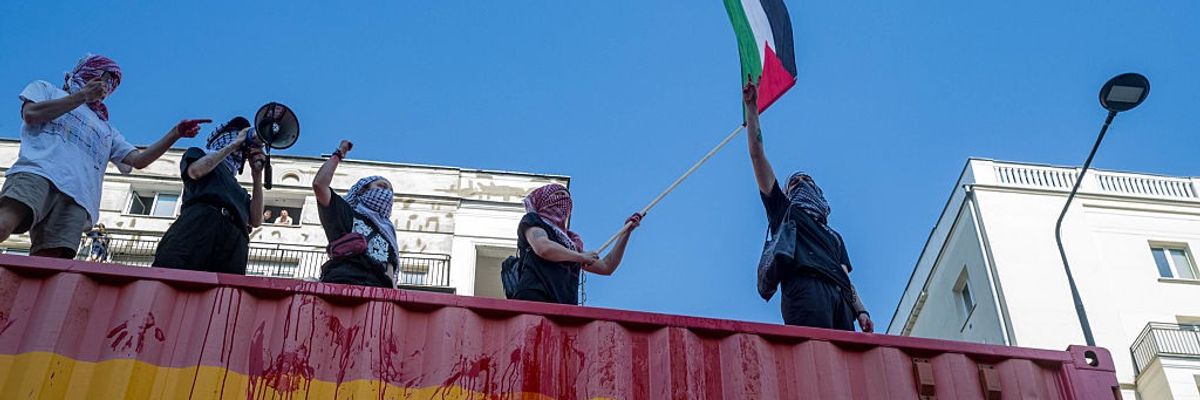 Protesters on top of the Maersk vehicle chant anti-genocide...