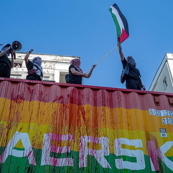 Protesters on top of the Maersk vehicle chant anti-genocide...
