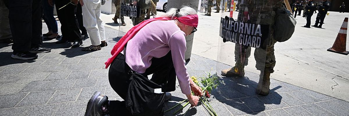 Protesters place flowers at feet of National Guard.
