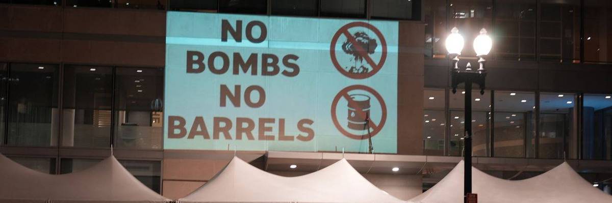 Protesters projected "No Bombs, No Barrels"
