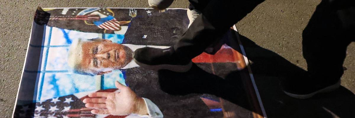 Protesters step on a Trump poster.