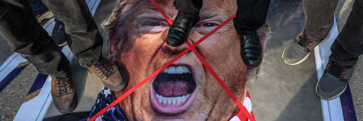 Protesters stomp on an image of Trump.