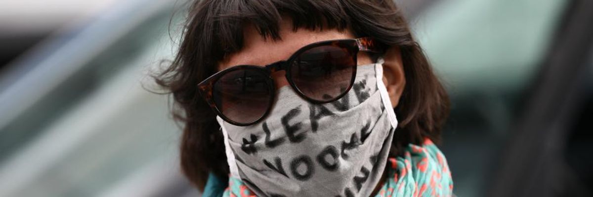 Protesters wearing protective face masks demonstrate while maintaining social distancing during the "MyGruni" Car parade on May Day during the novel coronavirus crisis on May 1, 2020 in Berlin, Germany