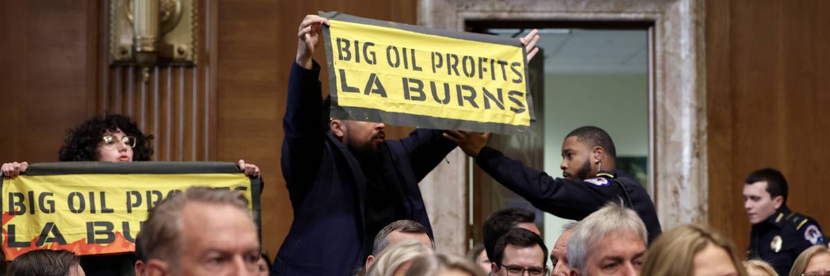 Protestor holds up sign that says "Big Oil Profits LA Burns"