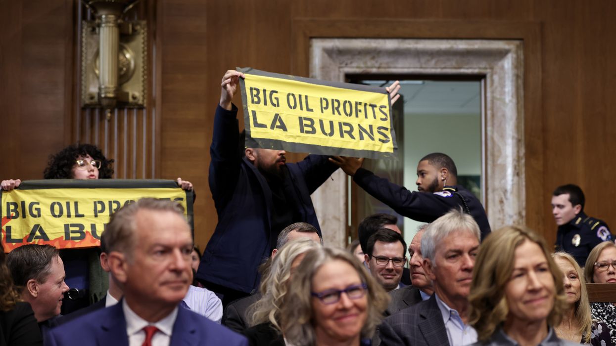 Protestor holds up sign that says "Big Oil Profits LA Burns"