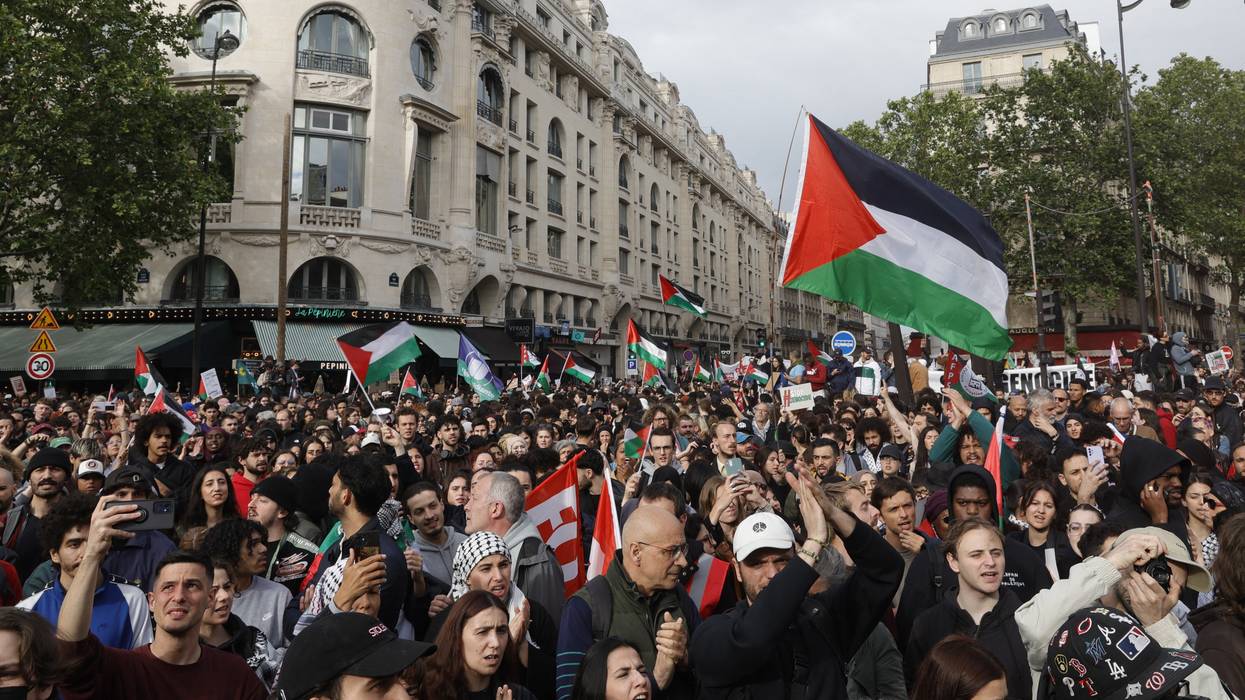 Protestors hold Palestinian flags during a demonstration in Paris