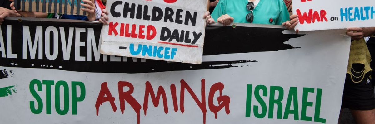 protestors hold pro-Palestinian placards in London