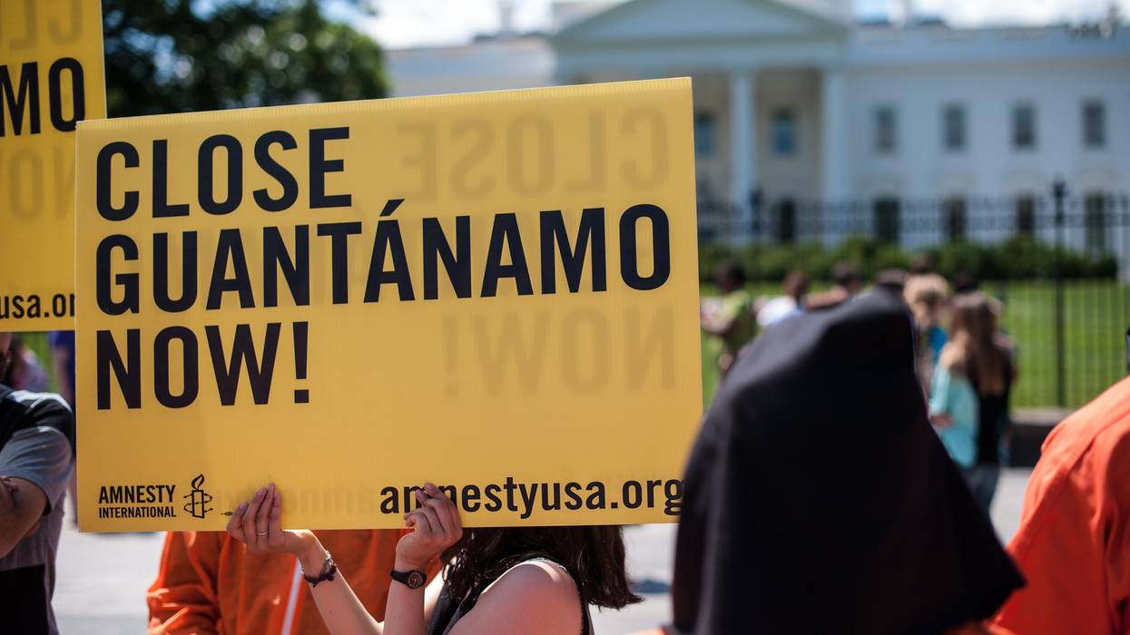 Protestors hold signs and wear orange jumpsuits to call for the closure of the Guantánamo Bay detention facility