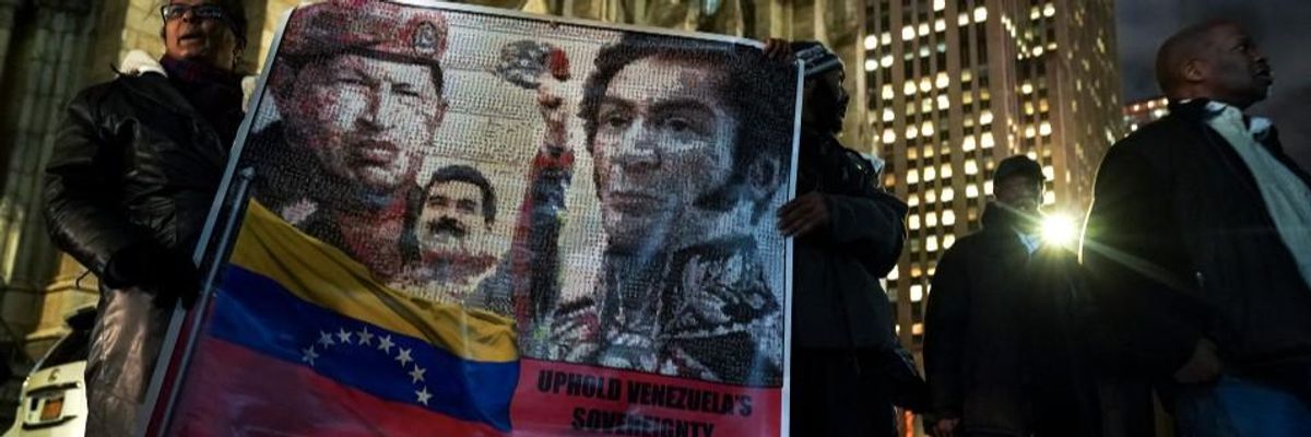 Protestors rally in support of Venezuelan President Nicolas Maduro as they hold a banner featuring the late former president of Venezuela Hugo Chavez, the current president of Venezuela Nicolas Maduro and 19th century Venezuelan military and political leader Simon Bolivar, outside the Venezuelan Consulate in Midtown Manhattan, January 24, 2019 in New York City