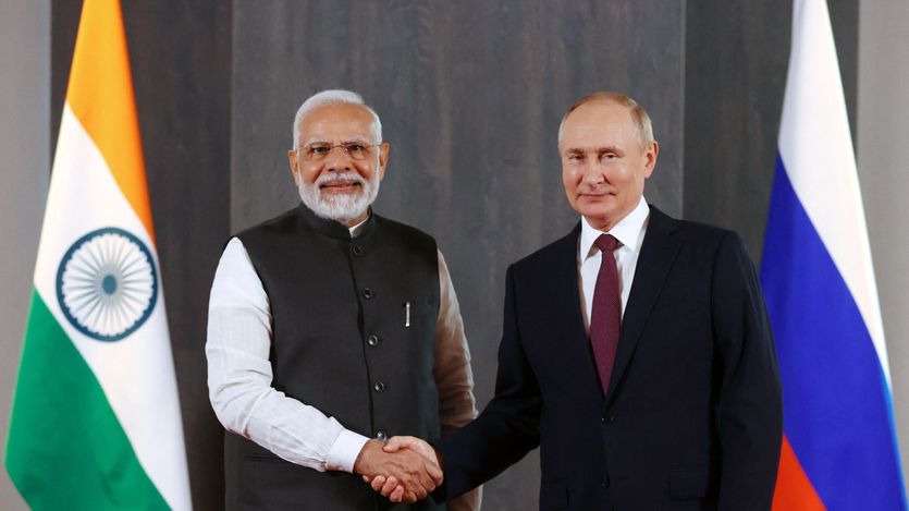 Putin and Modi shake hands.