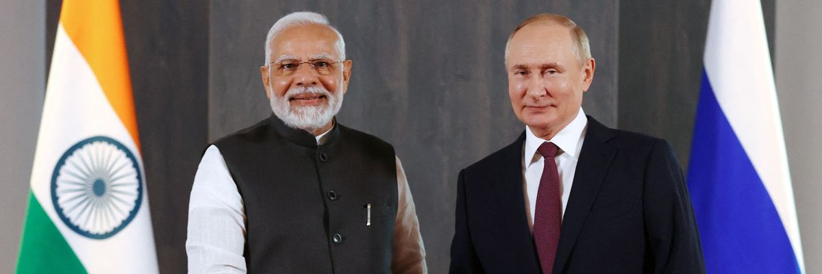 Putin and Modi shake hands.