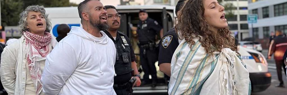 Rabbis and other Jews sing as they are arrested by NYPD officers