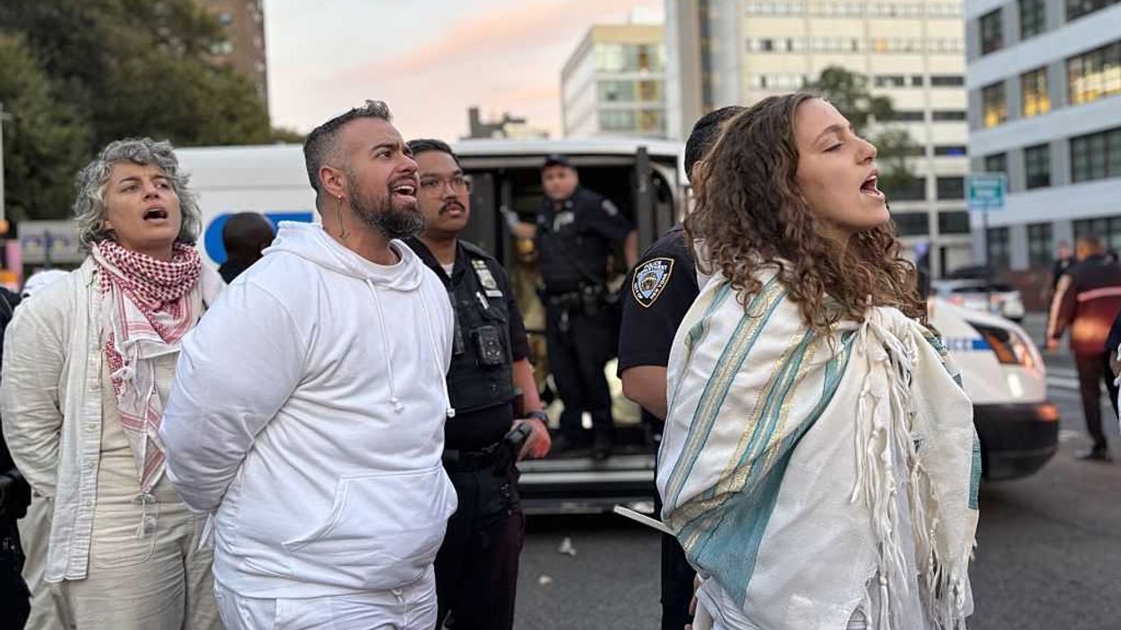 Rabbis and other Jews sing as they are arrested by NYPD officers