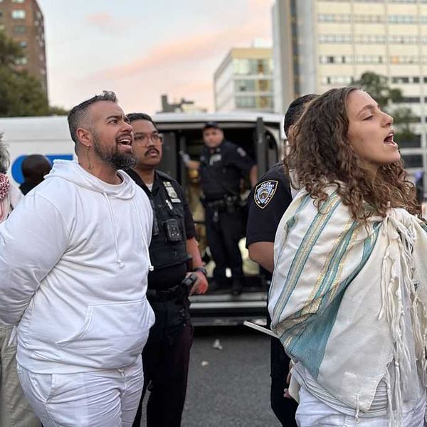 Rabbis and other Jews sing as they are arrested by NYPD officers