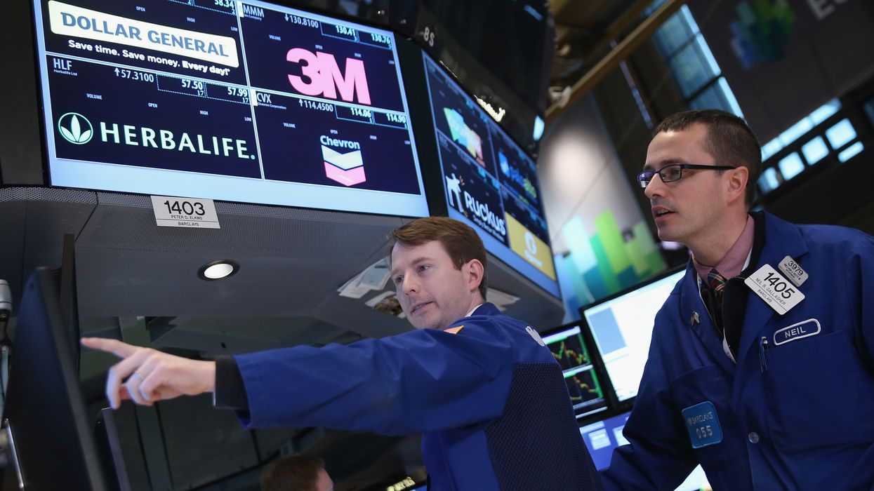 raders work the floor of the New York Stock Exchange as Helbalife stocks are traded on March 14, 2014 in New York City.