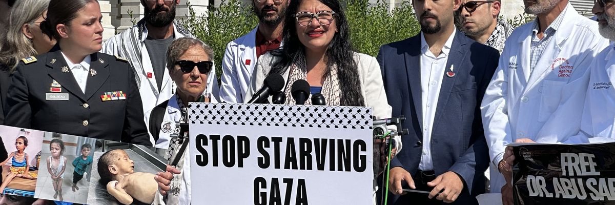 Rashida Tlaib holds a sign reading, "Stop Starving Gaza"