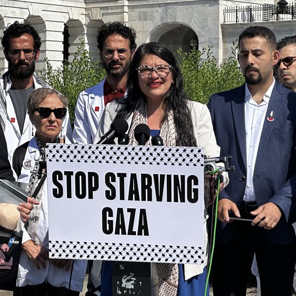 Rashida Tlaib holds a sign reading, "Stop Starving Gaza"