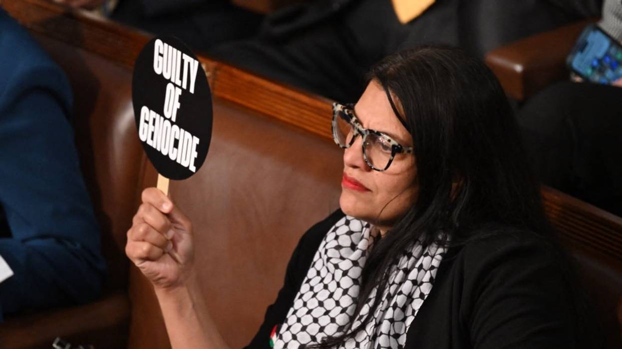 Rashida Tlaib holds a sign saying "guilty of genocide"