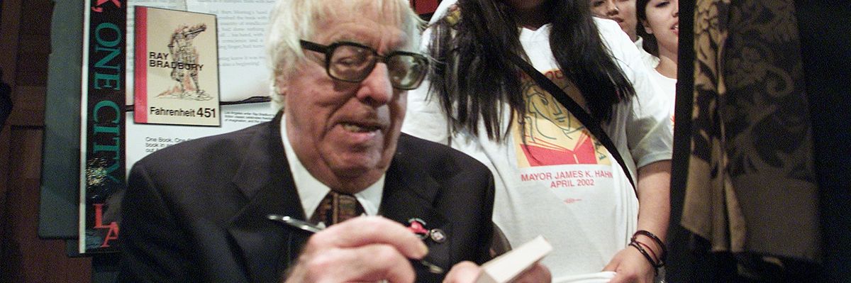 Ray Bradbury signs a book.