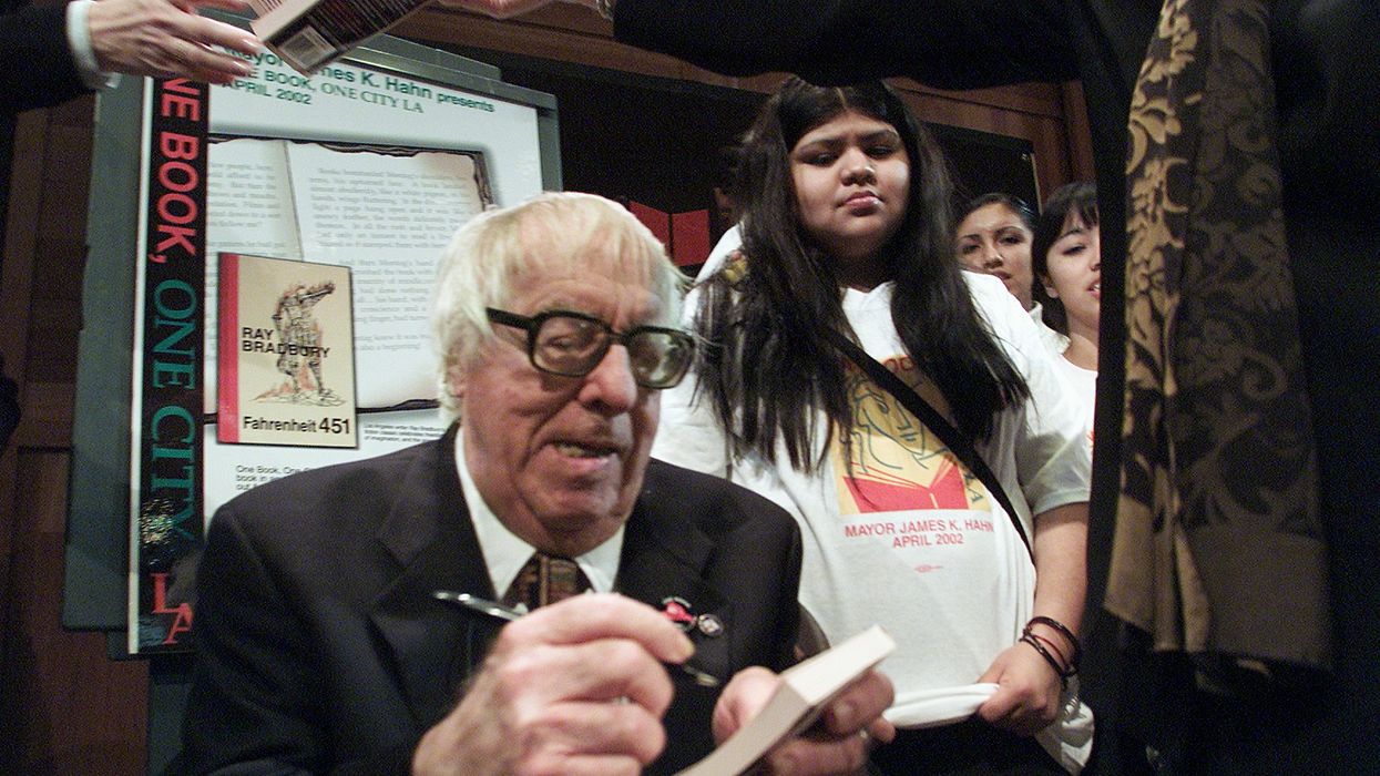 Ray Bradbury signs a book.