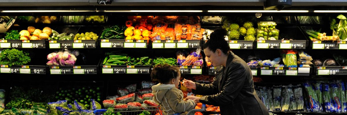Rebecka Ortiz offers a sample of pasta to her 3-year-old daughter at the grocery store where she was using her SNAP benefits to stock up on food for her family on March 1, 2013 in Woonsocket, Rhode Island. (Photo: Michael S. Williamson/Washington Post via Getty Images)