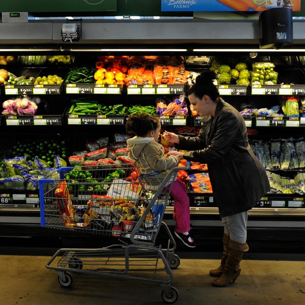 Rebecka Ortiz offers a sample of pasta to her 3-year-old daughter at the grocery store where she was using her SNAP benefits to stock up on food for her family on March 1, 2013 in Woonsocket, Rhode Island. (Photo: Michael S. Williamson/Washington Post via Getty Images)