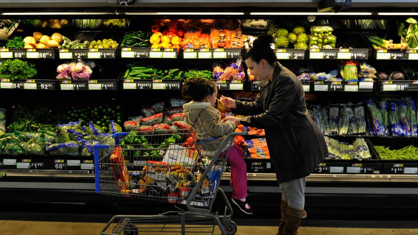 Rebecka Ortiz offers a sample of pasta to her 3-year-old daughter at the grocery store
