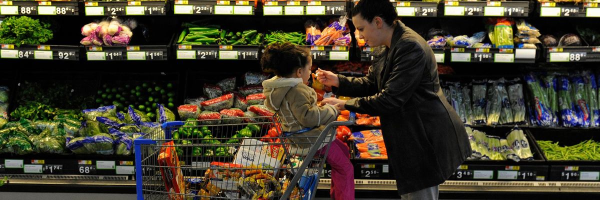 Rebecka Ortiz offers a sample of pasta to her 3-year-old daughter at the grocery store