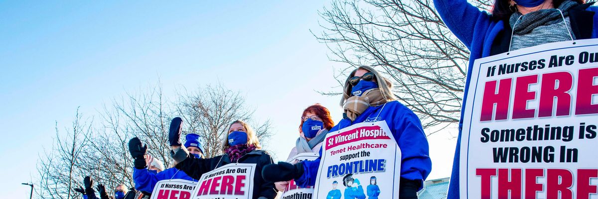 Registered Nurses and supporters stand in a picket line and wave to cars as they drive by outside St. Vincent Hospital in Worcester, Massachusetts on February 24, 2021. - 800 Nurses voted to go on strike starting March 8 after giving the hospital a ten day notice.