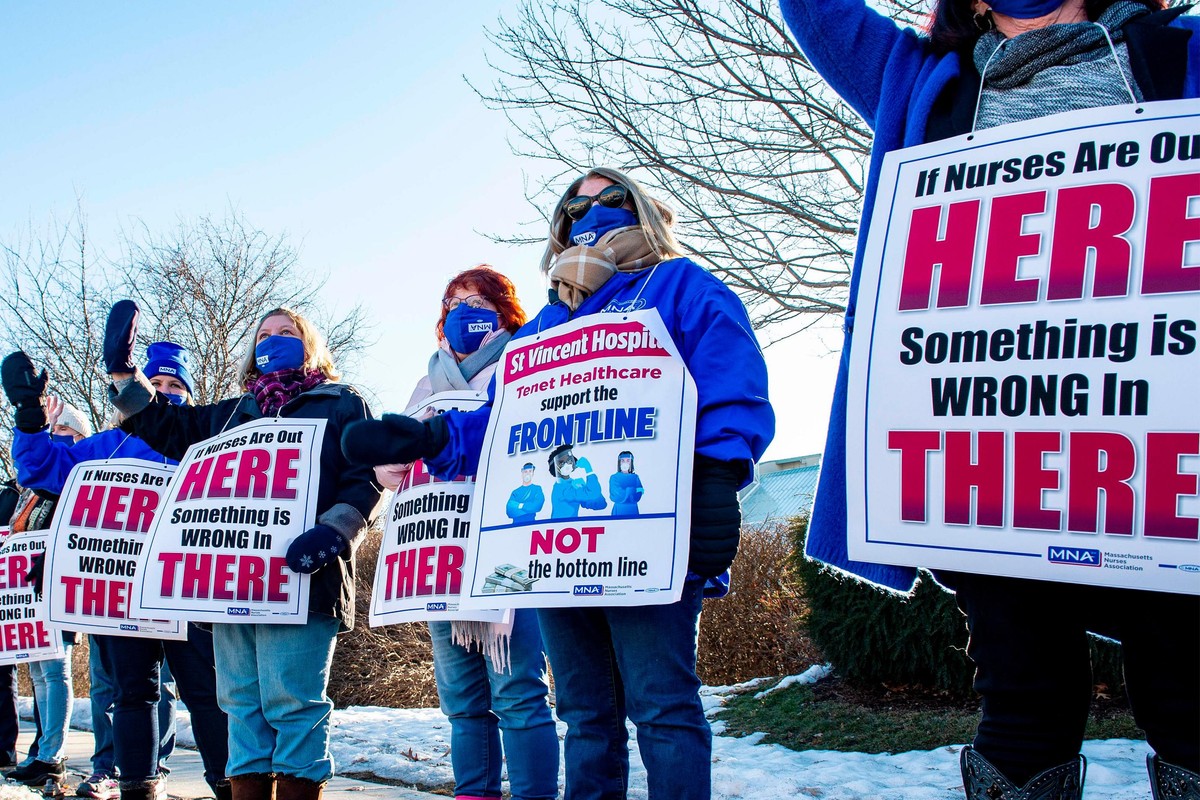 Registered Nurses and supporters stand in a picket line and wave to cars as they drive by outside St. Vincent Hospital in Worcester, Massachusetts on February 24, 2021. - 800 Nurses voted to go on strike starting March 8 after giving the hospital a ten day notice.
