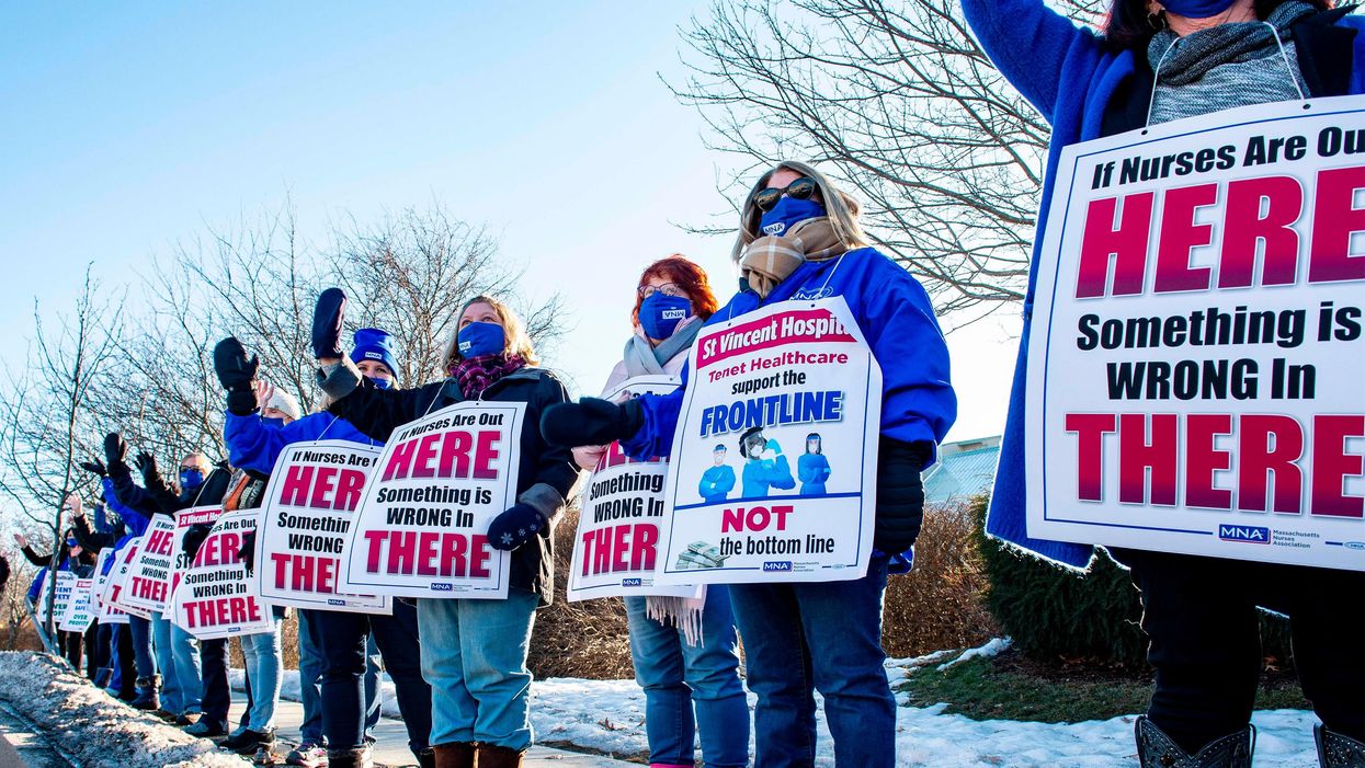 Registered Nurses and supporters stand in a picket line and wave to cars as they drive by outside St. Vincent Hospital in Worcester, Massachusetts on February 24, 2021. - 800 Nurses voted to go on strike starting March 8 after giving the hospital a ten day notice.