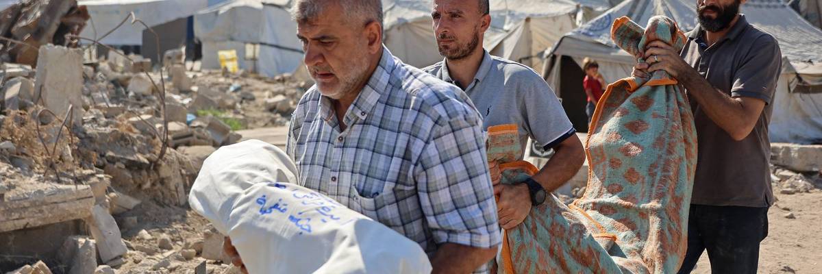 Relative of people killed in an Israeli airstrike on the home of a family carry victims' shrouded bodies