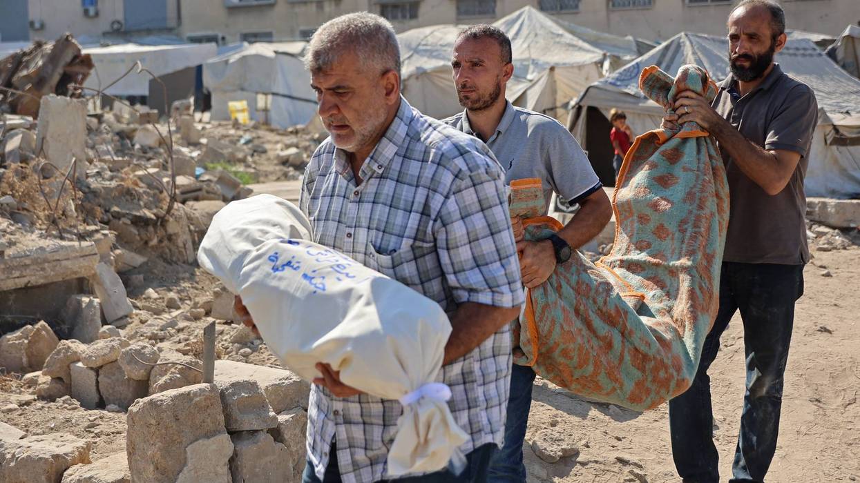 Relative of people killed in an Israeli airstrike on the home of a family carry victims' shrouded bodies