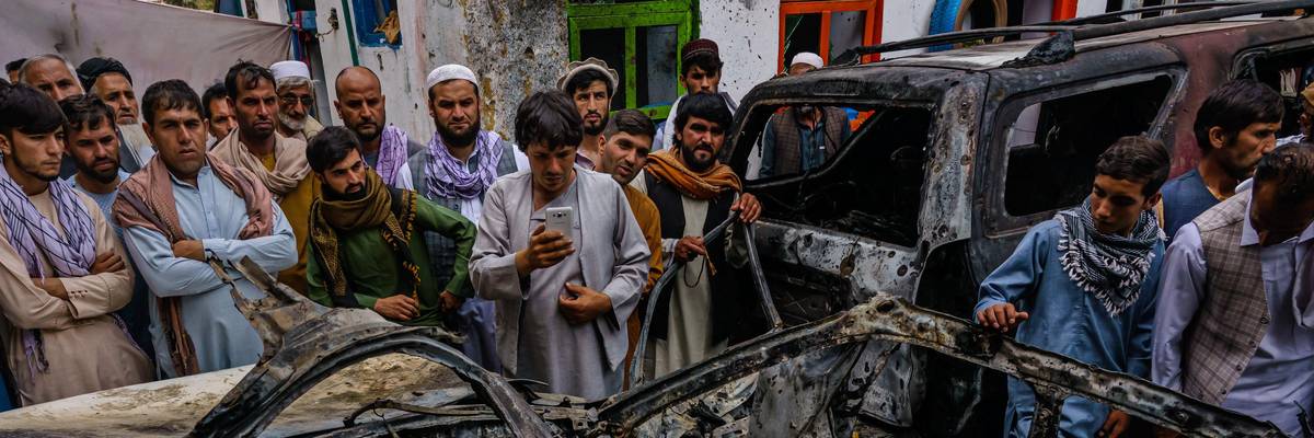 Relatives and neighbors of the Ahmadi family gathered around the incinerated husk of a vehicle hit by a U.S. drone strike in Kabul, Afghanistan on August 30, 2021.
