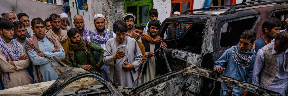 Relatives and neighbors of the Ahmadi family gathered around the incinerated husk of a vehicle hit by a U.S. drone strike in Kabul, Afghanistan on August 30, 2021.