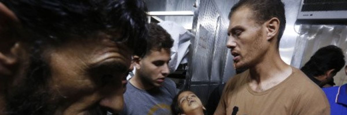 Relatives hold the body of a Palestinian girl in the morgue at Al-Shifa Hospital in Gaza City