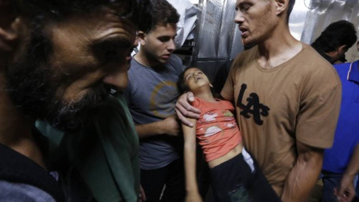 Relatives hold the body of a Palestinian girl in the morgue at Al-Shifa Hospital in Gaza City