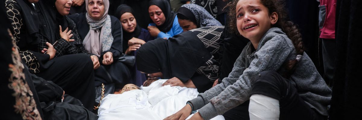 Relatives mourn over the bodies of two children killed in an Israeli strike