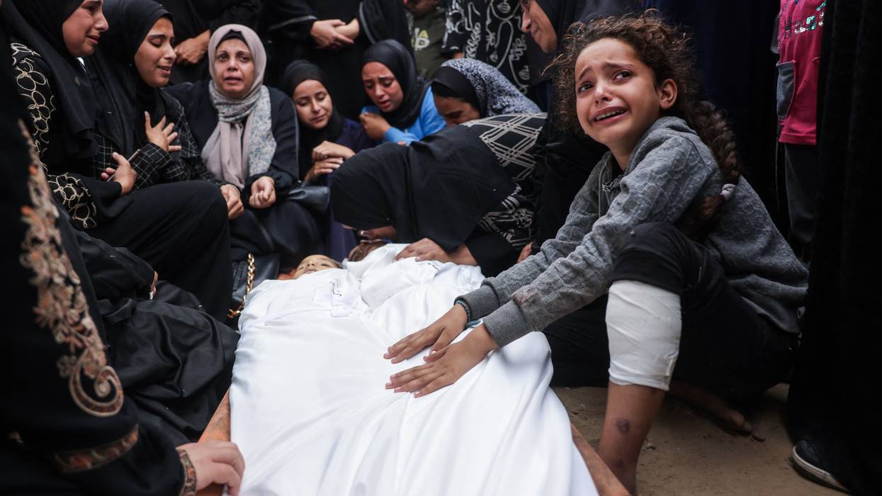 Relatives mourn over the bodies of two children killed in an Israeli strike