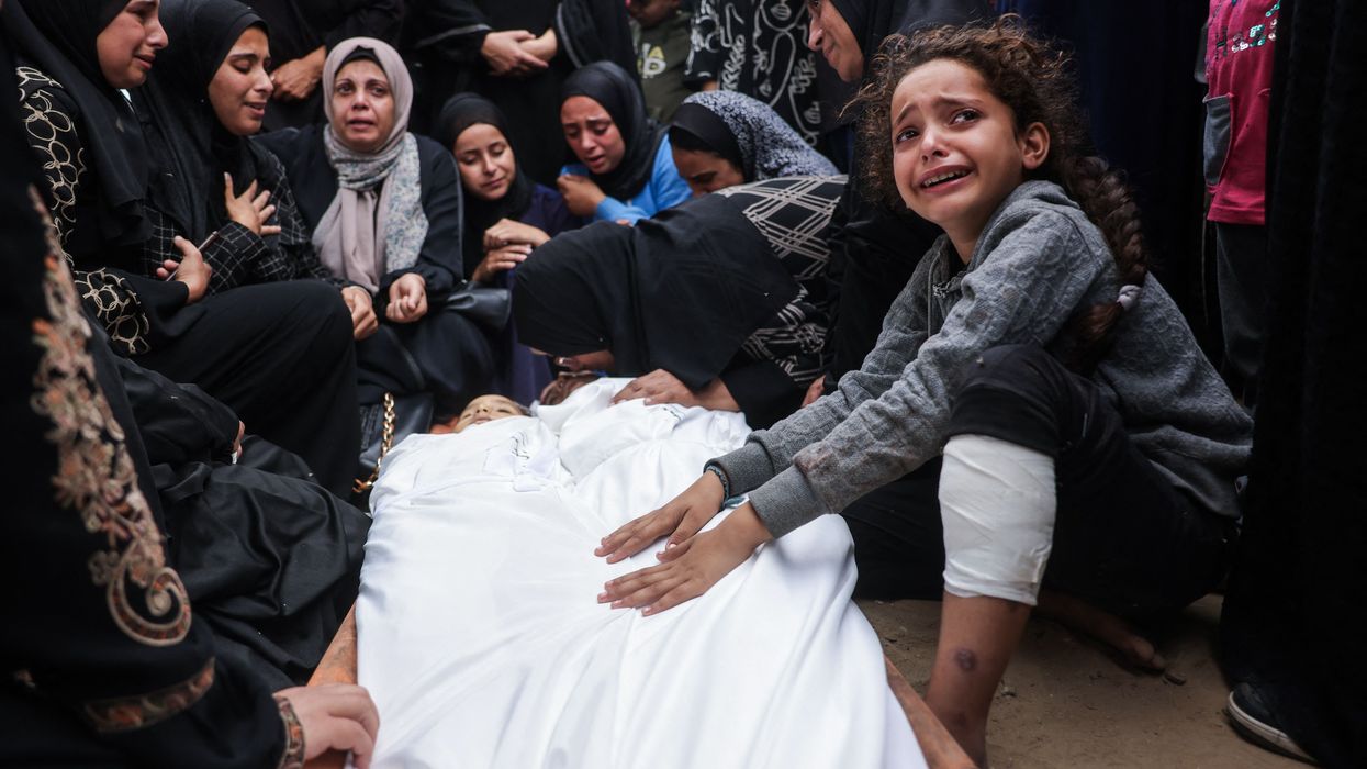 Relatives mourn over the bodies of two children killed in an Israeli strike