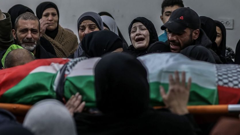 Relatives mourn over the body of Palestinian Yazan Al-Najmi 