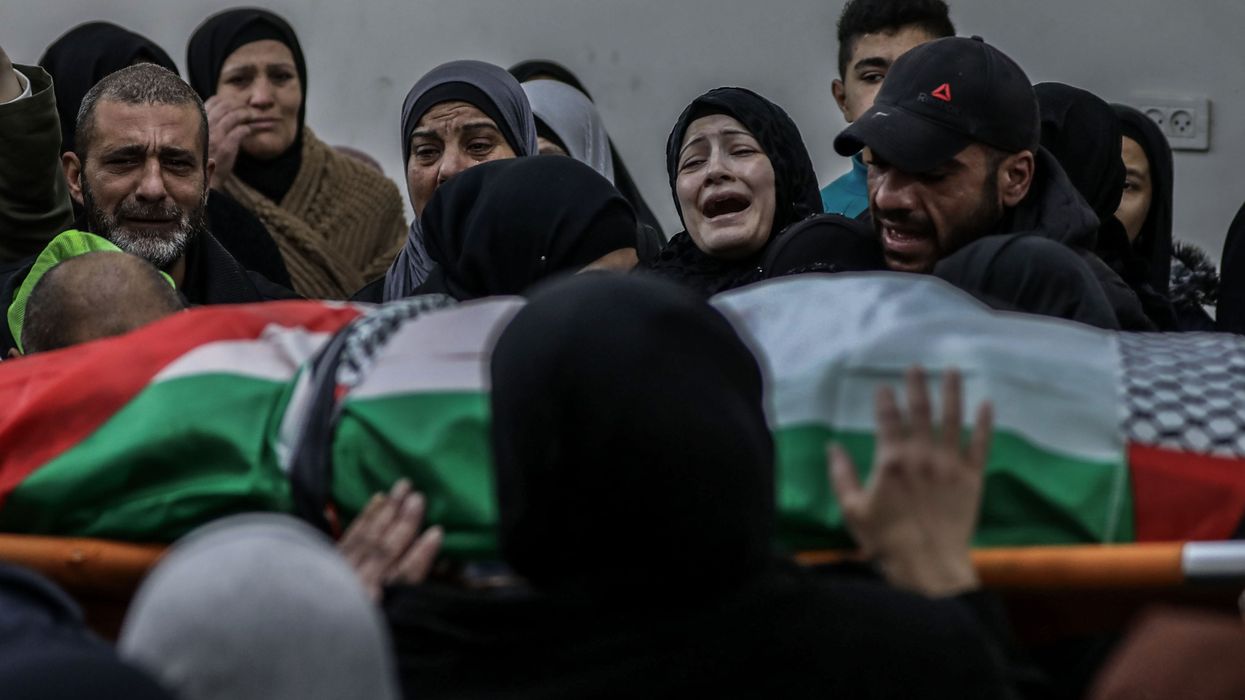 Relatives mourn over the body of Palestinian Yazan Al-Najmi