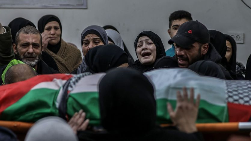 Relatives mourn over the body of Palestinian Yazan Al-Najmi