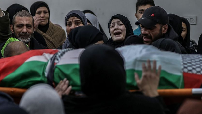 Relatives mourn over the body of Palestinian Yazan Al-Najmi