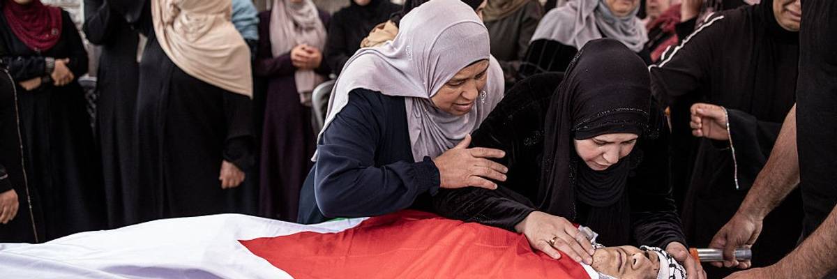 Relatives mourn over the flag-draped body of Omar Muhammad Rabea.