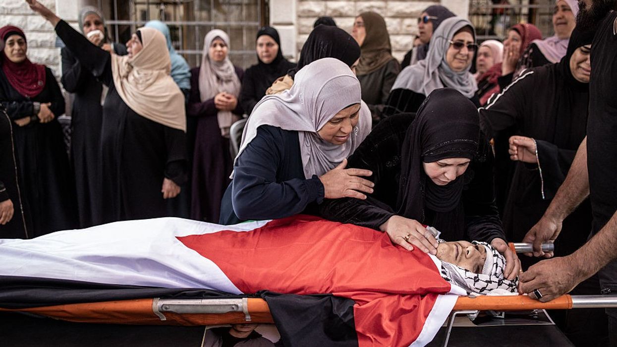 Relatives mourn over the flag-draped body of Omar Muhammad Rabea.