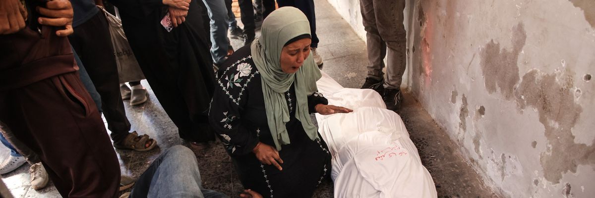 Relatives react over the shrouded body of a person killed in an Israeli strike