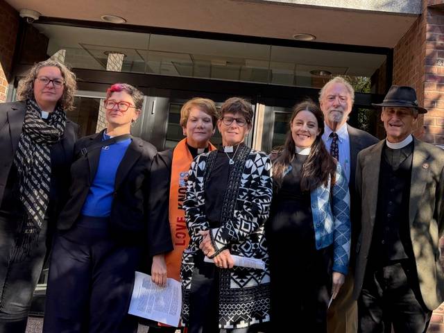 Religious leaders who conducted civil disobedience against ICE stand outside a courthouse.