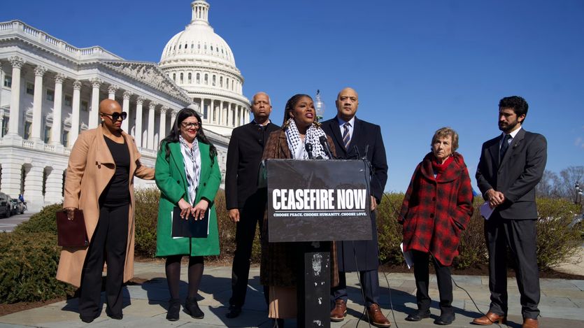 Rep. Cori Bush speaks outside the U.S. Capitol with a "cease-fire now" sign on the podium.