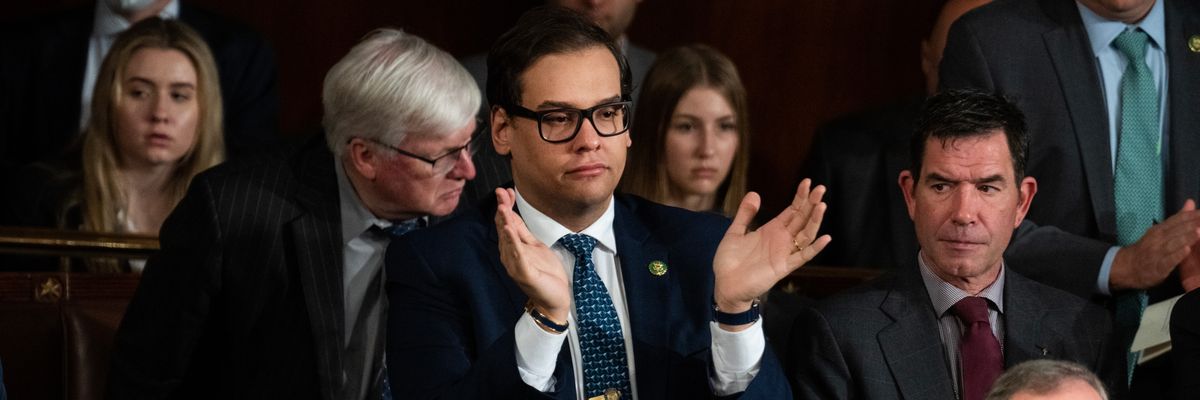 Rep. George Santos applauds in the House chamber